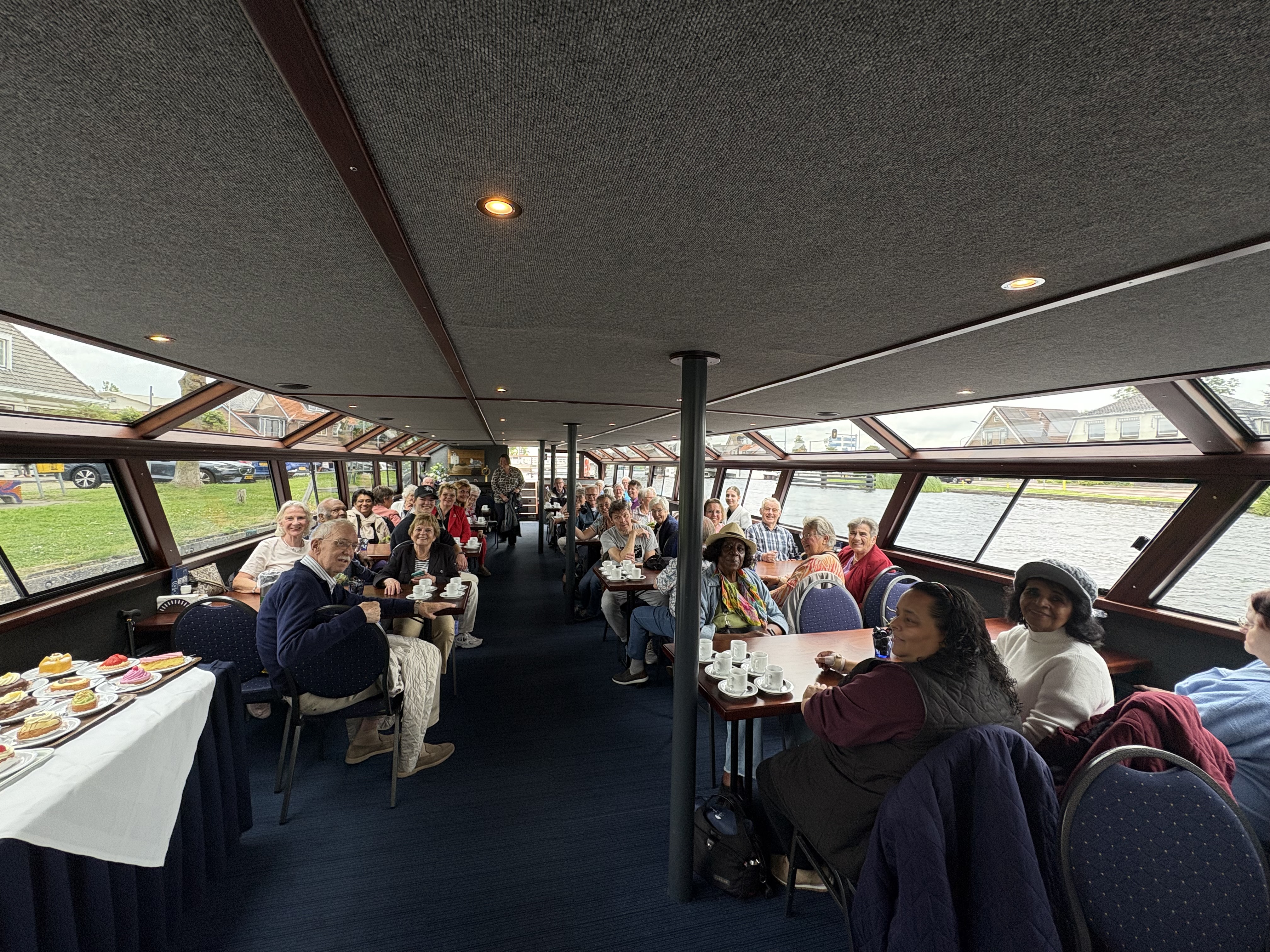 Een rondvaartboot vol mensen die blij naar de camera kijken.